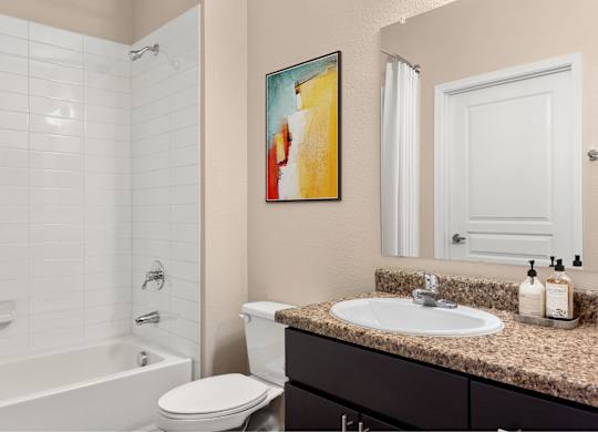 A bathroom with a white toilet, a sink, and a painting on the wall.