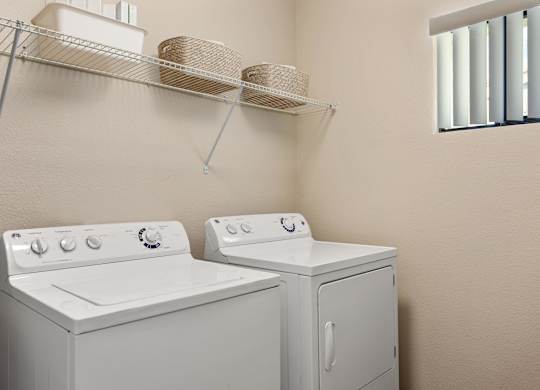 A white washing machine and dryer in a small laundry room.