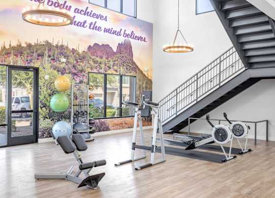 A gym with a staircase and exercise equipment.