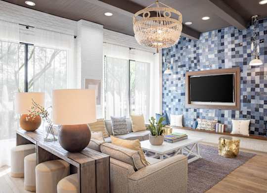 A modern living room with a large sofa, a wooden coffee table, and a chandelier.