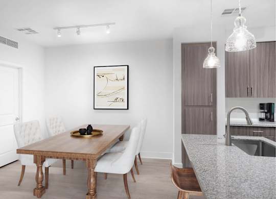 A modern dining room with a wooden table and white chairs.