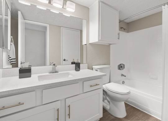 A white bathroom with a toilet, sink, and mirror.