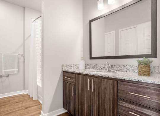 A bathroom with a wooden cabinet and a white countertop.
