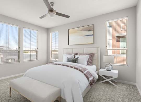 A bedroom with a large bed and a ceiling fan.