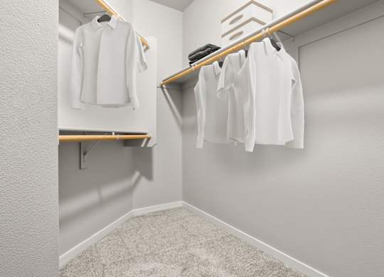 A white shirt is hanging on a wooden hanger in a white closet.