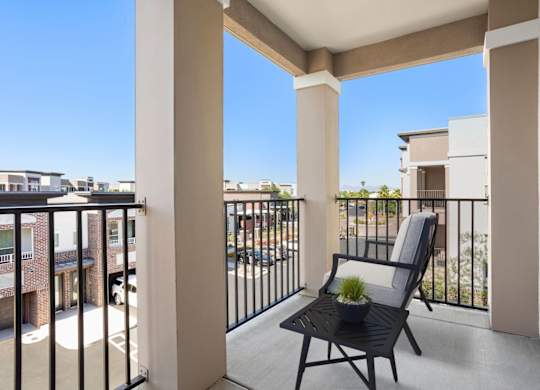 A balcony with a chair and a potted plant.