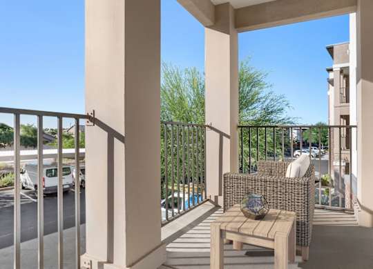 A balcony with a bench and a table with a globe on it.