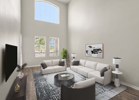 A living room with a white couch, a coffee table, and a flat screen TV.