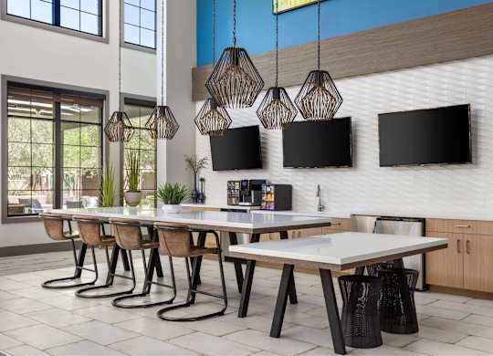 A modern dining room with a long table and chairs.