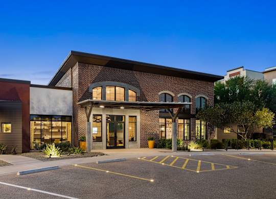 A modern building with a parking lot in front.