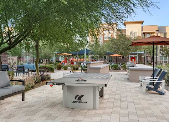 A table tennis table is in the middle of a patio.