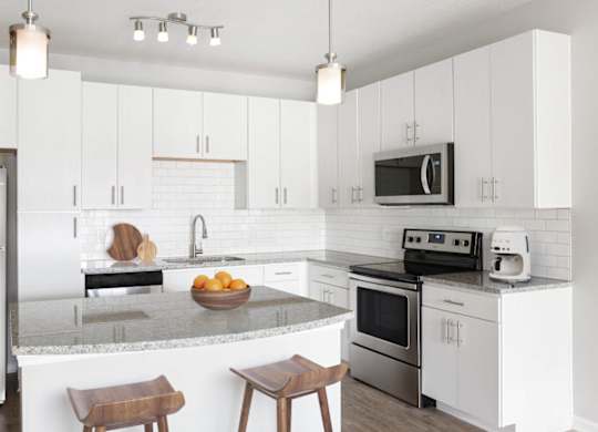 A modern kitchen with white cabinets and stainless steel appliances.