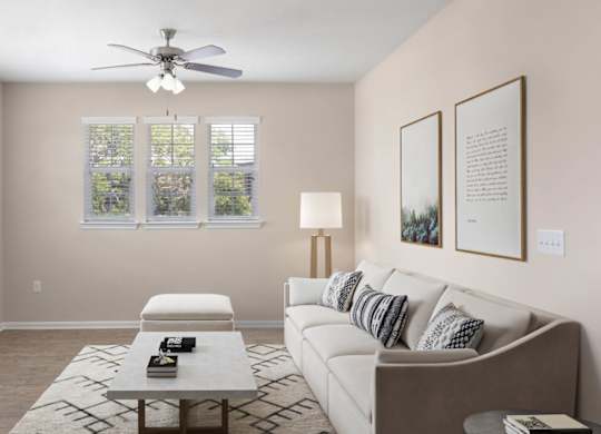 A living room with a couch, a coffee table, and a ceiling fan.