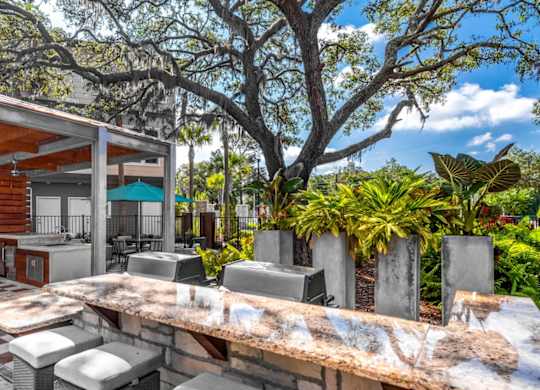 A wooden outdoor kitchen with a grill and sink.