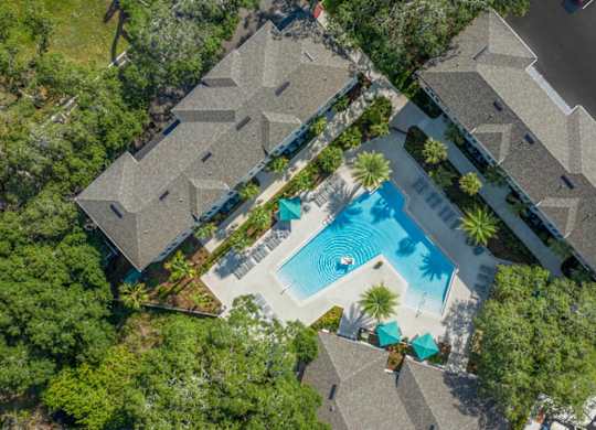 An aerial view of a residential area with houses and a swimming pool.