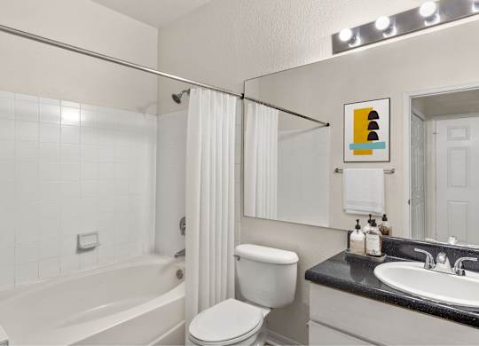 A white bathroom with a white toilet, sink, and bathtub.