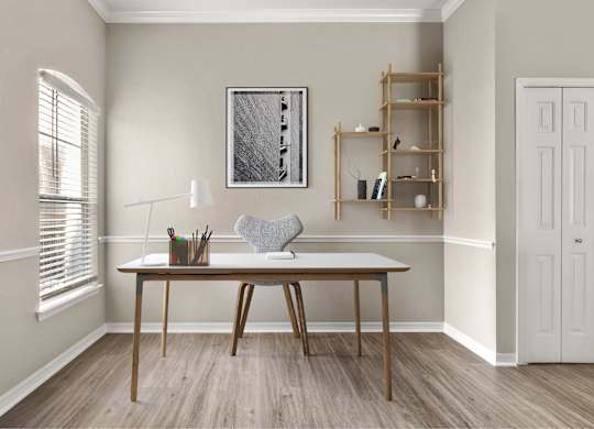 A room with a table, a chair, and a shelf with a picture frame on the wall.