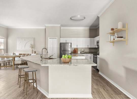 A kitchen with a white island and wooden floors.