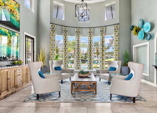 A living room with a large window and a view of a pool.