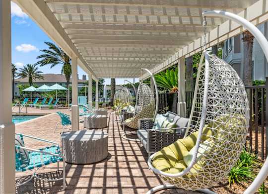 A white patio with a white canopy and a white chair.