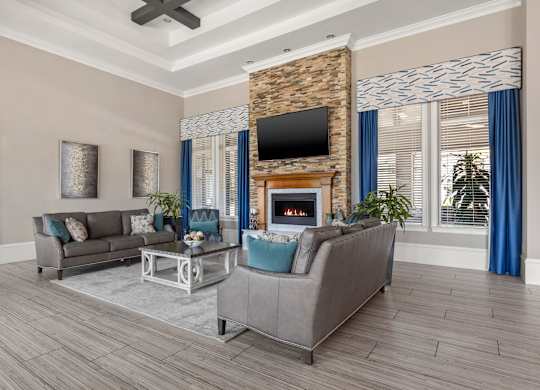 A living room with a grey couch, a fireplace, and a television.