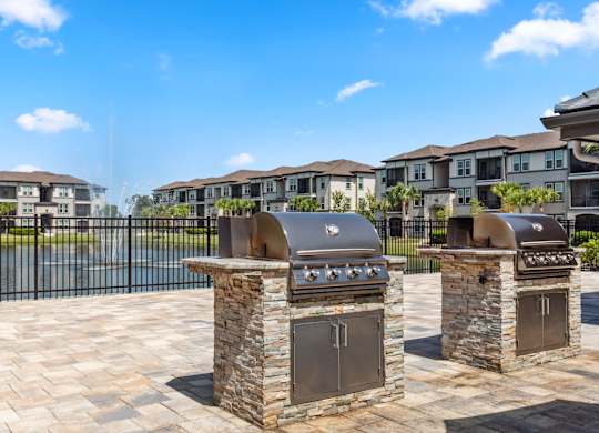 Two stone BBQs in front of apartment buildings.