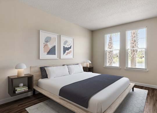 A bedroom with a large bed and two lamps on side tables.