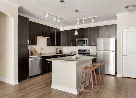 A kitchen with a white island and a white refrigerator.