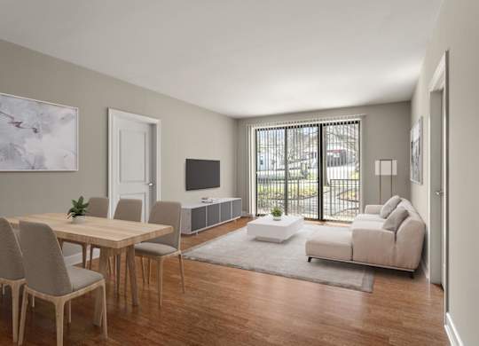 A modern living room with a wooden table and chairs, a white sofa, and a television.