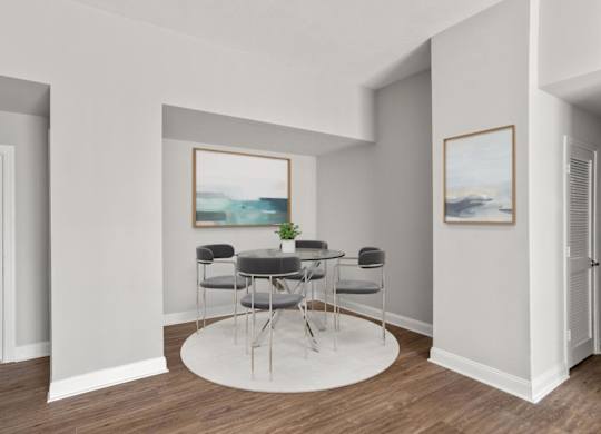 A room with a table and chairs and a painting on the wall.