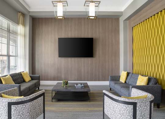 A modern living room with grey sofas and a black television.