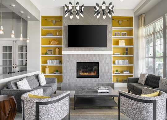 A modern living room with a grey fireplace and a television mounted above it.
