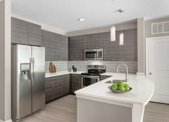 A modern kitchen with a stainless steel refrigerator and a white countertop.