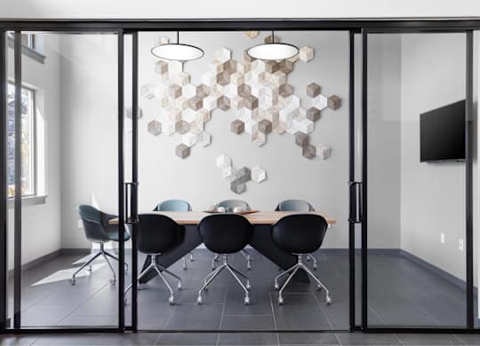 A conference room with a glass table and chairs.