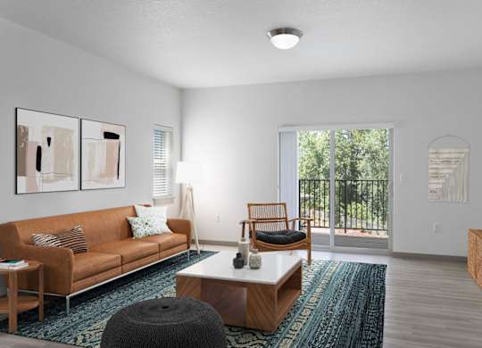 A living room with a brown couch, a coffee table, and a large window.