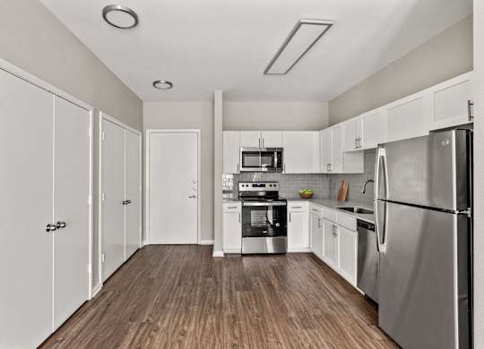 A kitchen with white cabinets and stainless steel appliances.