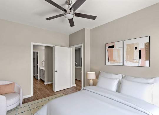 A bedroom with a white bed and a ceiling fan.
