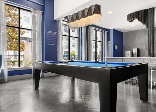 A pool table in a room with a blue wall.