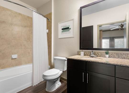 A bathroom with a toilet, sink, and shower.