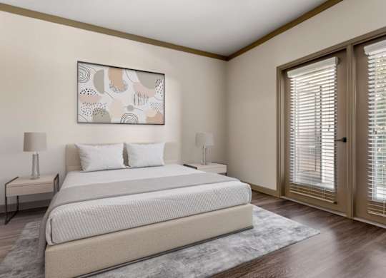 A bedroom with a large bed, two lamps, and a painting on the wall.