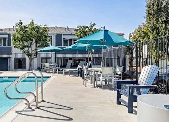 A poolside area with chairs and a table.