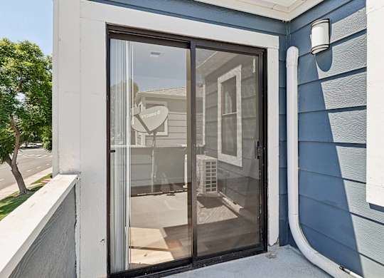 A blue house with a glass door and a sign that says "Welcome".