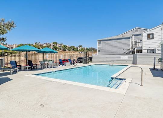 A swimming pool with a slide and a fence.