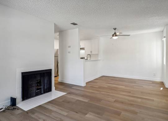 A room with a fireplace and wooden floors.