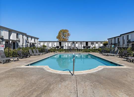 A swimming pool in front of apartment buildings.
