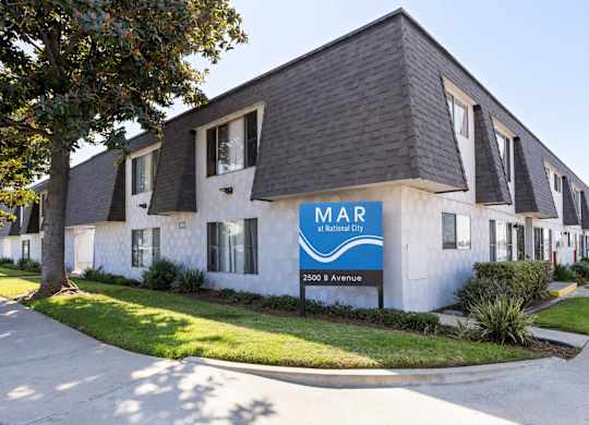 A white building with a blue sign that says MAR on it.