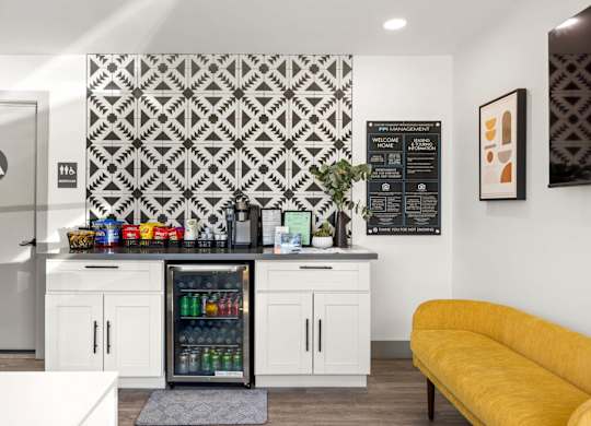 A kitchen with a yellow couch and a patterned wallpaper.