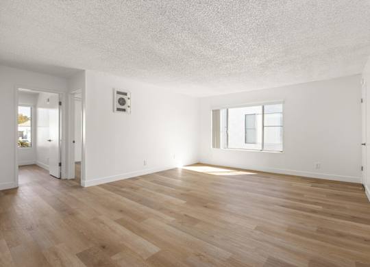 A room with wooden flooring and a window.