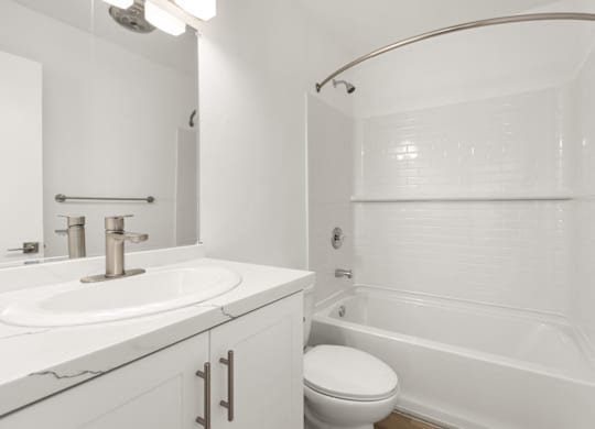 A white bathroom with a sink, toilet, and bathtub.