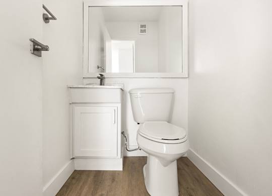 A white toilet and sink in a small bathroom.
